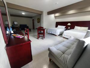 a hotel room with two beds and a couch at Hotel Maria del Carmen in Mérida