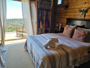 a bedroom with a large bed with a large window at Ático FUENTE HERVERA in Vega de San Mateo