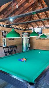 a green pool table in a room with a ceiling at Chalé Gigante Adormecido in Joanópolis
