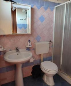 een badkamer met een toilet, een wastafel en een spiegel bij villa da sogno in vetro in Castellammare del Golfo