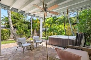 a patio with a tub and chairs and a ceiling fan at The Naples Bungalow in Naples