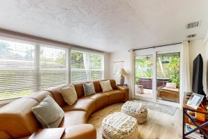 ein Wohnzimmer mit einem großen braunen Sofa und Fenstern in der Unterkunft The Naples Bungalow in Naples