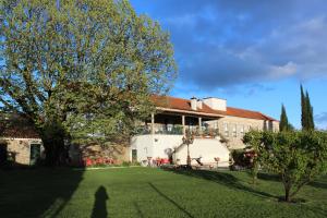 un edificio con un árbol delante de un patio en Solar Quinta de São Carlos en Viseu