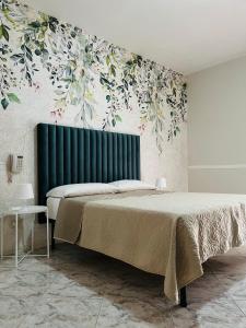 um quarto com uma cama grande e uma cabeceira verde em Hotel Stefany em Lago Patria