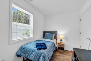 a bedroom with a bed with blue sheets and a window at Cozy 2BR Getaway Just 3 5 Blocks to Beach & Boards in Belmar