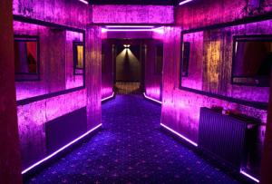 北马马亚-讷沃达里Hotel Boutique18plus - Adults Only的一间房间里一条带紫色灯的空走廊