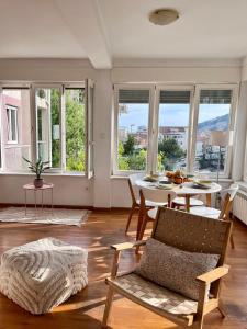 ブドヴァにあるSunny apartmentsのテーブルと椅子と窓のあるリビングルーム