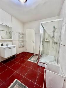 ブドヴァにあるSunny apartmentsの赤いタイルフロアのバスルーム(シャワー付)
