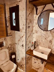 a bathroom with a sink and a toilet and a mirror at M Boutique Apartments in Thessaloniki