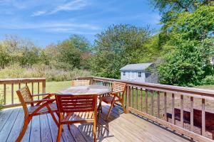 a wooden deck with a table and chairs on it at Far Away by the Sea in Yarmouth