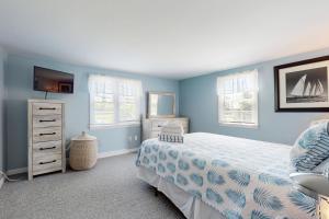 a bedroom with blue walls and a bed and a dresser at Far Away by the Sea in Yarmouth