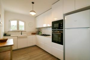a kitchen with white cabinets and a refrigerator at FLH Altura Family House with Pool in Altura