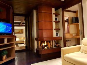 a living room with a fireplace and a television at Luxuoso Flat no Laje de Pedra -Mountain Village in Canela