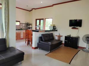 een woonkamer met een bank en een tafel bij Links Sunset Beach House in Nathon Bay