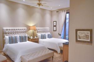 1 dormitorio con 2 camas, silla y ventana en Bastión Luxury Hotel, en Cartagena de Indias