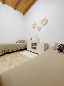 two beds in a room with white walls at HOSPEJADE ESQUINA in Esquina