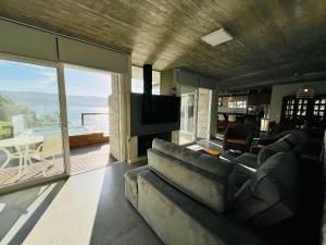 a living room with a couch and a flat screen tv at Spa Jacuzzi, Lareira, Beira mar, 4 Suítes in Garopaba