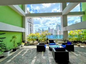 een patio met blauwe stoelen en uitzicht op de stad bij Yc l Estudio av Balboa - GB701A in Panama-Stad