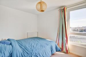 ein Schlafzimmer mit einem blauen Bett und einem Fenster in der Unterkunft Duplex 3 chambres grande terrasse dernier étage in Nanterre