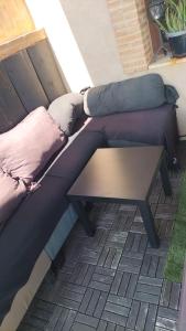a couch with pillows sitting next to a table at Apartamento un Dormitorio in Valdepeñas