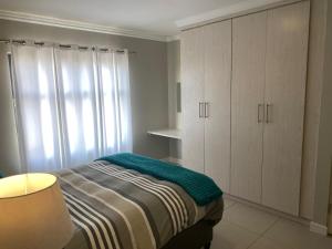 a bedroom with a bed and white cabinets at The little Falls Lifestyle Estate in Roodepoort +3 photos
