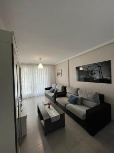 een woonkamer met een bank en een tafel bij Apartamento Miriam in Cudón +15 foto's