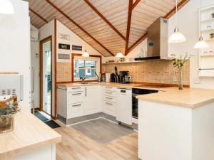 uma cozinha com electrodomésticos brancos e um tecto de madeira em Three-Bedroom Holiday home in Hemmet 26 em Hemmet
