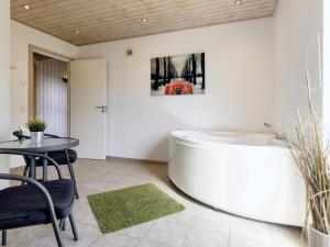 10 person holiday home in Storvorde في Egense: حوض استحمام في غرفة مع طاولة وطاولة