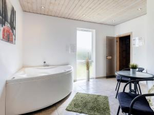 eine große weiße Badewanne in einem Zimmer mit einem Tisch in der Unterkunft 10 person holiday home in Storvorde in Egense