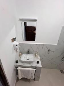 uma casa de banho branca com um lavatório e um espelho em Nungwi Beach Front Ex Sunrise Beach Nungwi em Nungwi