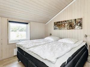 Four-Bedroom Holiday home in Storvorde في Egense: سرير كبير في غرفة مع نافذة