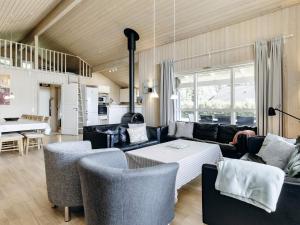 Four-Bedroom Holiday home in Storvorde في Egense: غرفة معيشة مع أريكة وكراسي وطاولة
