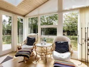 a screened in porch with chairs and a table and windows at 6 person holiday home in Storvorde in Storvorde