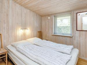 a large bed in a room with wooden walls at 6 person holiday home in Storvorde in Storvorde