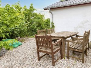 un tavolo in legno e 2 sedie posti accanto a un patio di 6 person holiday home in Thisted ad Arup