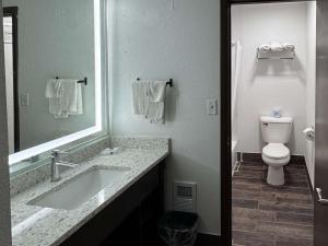 a bathroom with a sink and a toilet and a mirror at Best Nights Hotel in Fond du Lac +13 photos