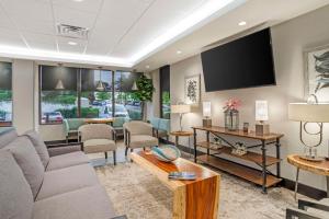 a living room with a couch and a flat screen tv at Best Western Plus Greenville I-385 Inn & Suites in Greenville