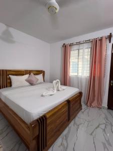 1 dormitorio con 1 cama con sábanas blancas y ventana en Nungwi Beach Front Ex Sunrise Beach Nungwi en Nungwi