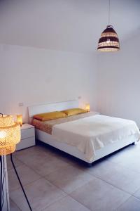 ein Schlafzimmer mit einem großen weißen Bett und einer Lampe in der Unterkunft Apartment on the beach in Roseto in Roseto degli Abruzzi