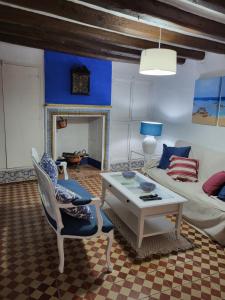 ein Wohnzimmer mit einem Sofa und einem Tisch in der Unterkunft Casa de pueblo, entre mar y montaña, con spa. Plaza Mayor in Sant Jordi