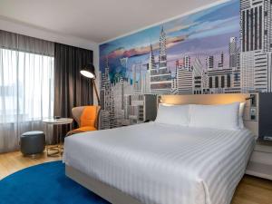 um quarto com uma cama branca e um mural da cidade em Novotel Bangkok on Siam Square em Bangkok