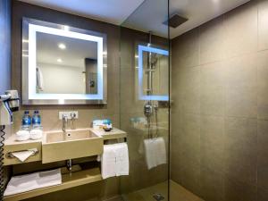 La salle de bains est pourvue d'un lavabo et d'une douche. dans l'établissement Novotel Bangkok on Siam Square, à Bangkok