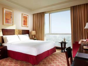 فندق بولمان زمزم مكة في مكة المكرمة: سرير كبير في غرفة الفندق مع نافذة كبيرة