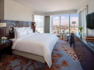 فندق سويس اوتيل مكة  في مكة المكرمة: غرفة نوم بسرير ابيض كبير ونافذة كبيرة