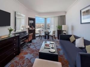 فندق سويس اوتيل مكة  في مكة المكرمة: غرفة معيشة مع أريكة زرقاء ومكتب