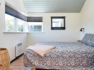 a bedroom with a bed and two windows at Holiday home Tarm XLIV in Tarm