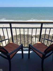 2 sillas sentadas en un balcón con vistas a la playa en Best Western Ocean Sands Beach Resort, en Myrtle Beach