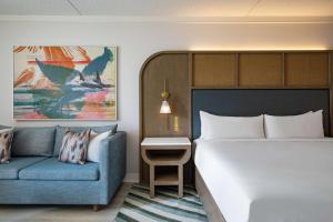 Sonesta Resort Hilton Head Island في جزيرة هيلتون هيد: غرفة نوم بسرير واريكة زرقاء