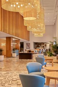 a lobby with chairs and tables and a large chandelier at Radisson Blu Resort Al Hoceima in Al Hoceïma