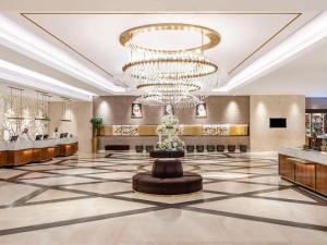 a large lobby with a large chandelier and a fountain at Movenpick Makkah Hajar Tower in Makkah